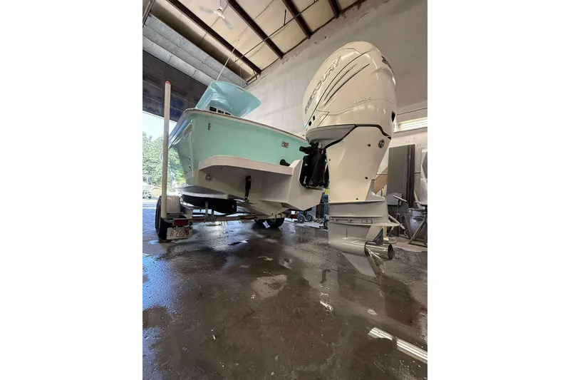 Slide: The Image of 1996 Silverhawk 24 boat with Mercury Verado engine in a garage setting. - 2