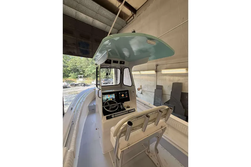 Slide: The Image of 1996 Silverhawk 24 boat interior with modern dashboard and seating in a garage setting. - 5