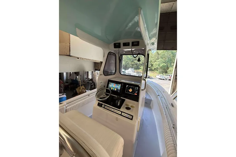 Slide: The Image of 1996 Silverhawk 24 boat interior with modern navigation equipment and steering wheel. - 6