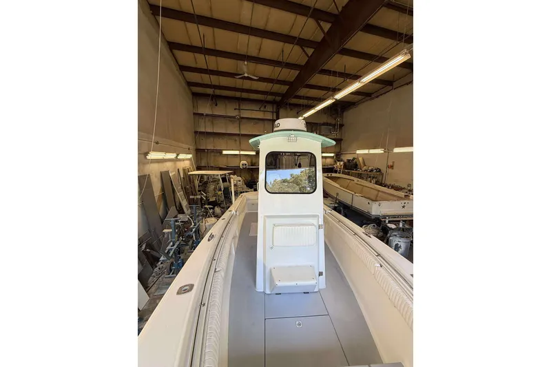 Slide: The Image of 1996 Silverhawk 24 boat in a workshop, showcasing its deck and cabin. - 8