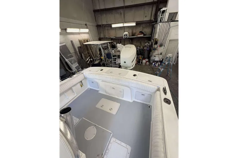 Slide: The Image of 1996 Silverhawk 24 boat interior in a workshop, showcasing spacious deck and storage compartments. - 9