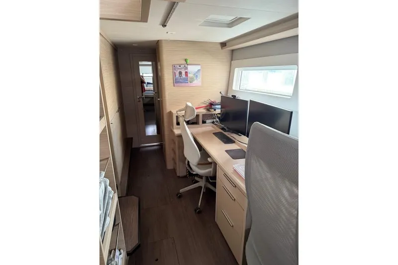 Slide: The Image of Modern office setup inside 2023 Lagoon 46 yacht, featuring dual monitors and ergonomic chair. - 1