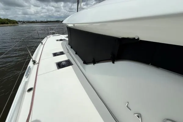 Slide: The Image of 2023 Lagoon 46 catamaran deck view on a cloudy day. - 11
