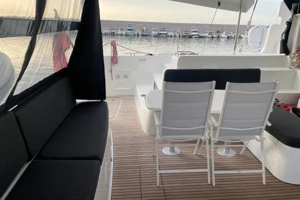 Slide: The Image of 2023 Lagoon 46 yacht deck with seating area, overlooking marina. - 14
