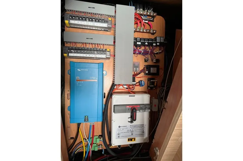 Slide: The Image of Electrical panel inside 2023 Lagoon 46 yacht, featuring wiring and control systems. - 27