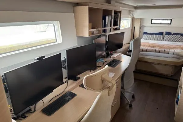 Slide: The Image of Modern office setup inside 2023 Lagoon 46 yacht with multiple monitors and workspace. - 3