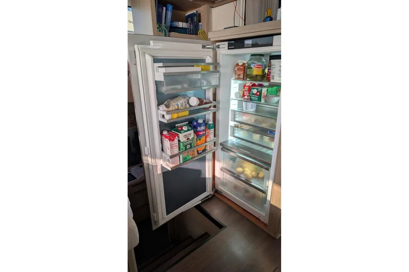 Slide: The Image of Open refrigerator on Lagoon 46 yacht, stocked with various food items and beverages. - 8