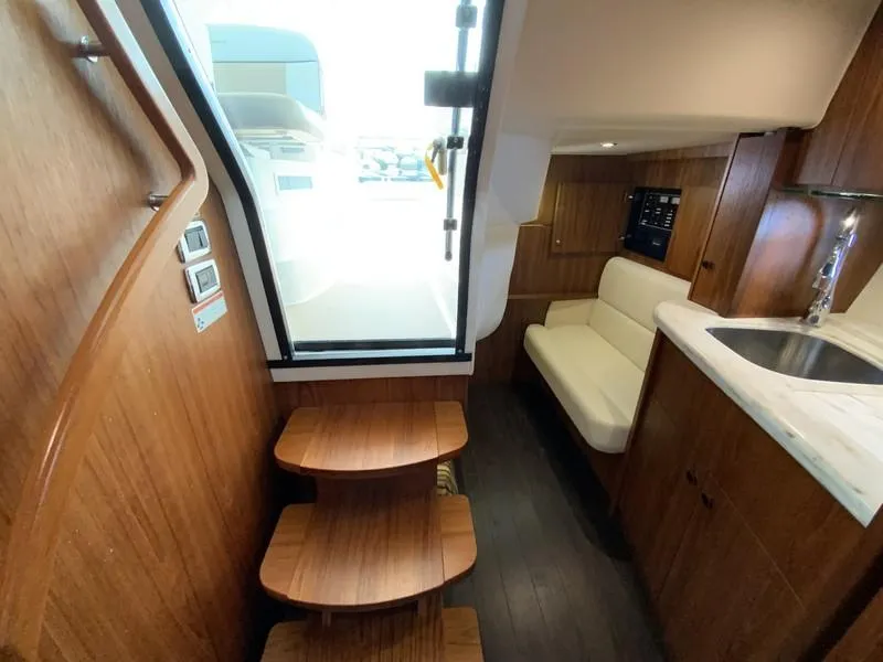 Slide: The Image of Interior of 2013 Tiara Yachts 36, featuring wooden steps, seating, and kitchenette. - 24