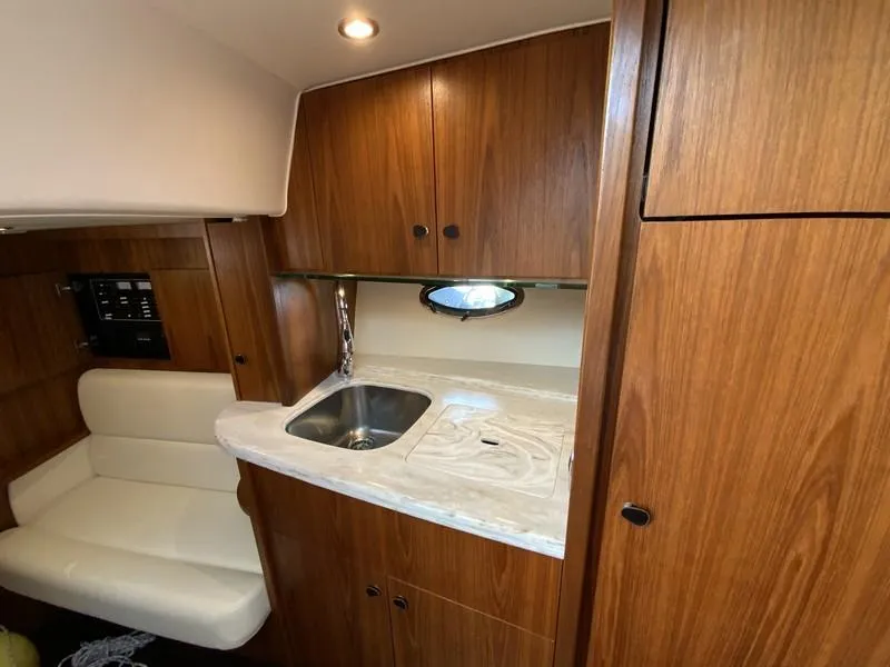 Slide: The Image of 2013 Tiara Yachts 36 interior with wooden cabinetry and compact kitchenette. - 25