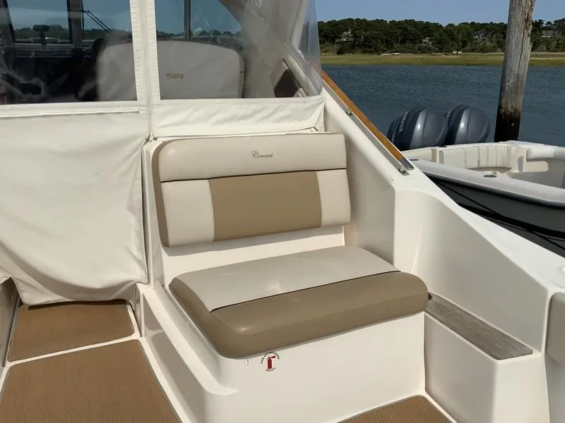Slide: The Image of 2013 Tiara Yachts 36 interior seating with beige cushions, docked by the water. - 6