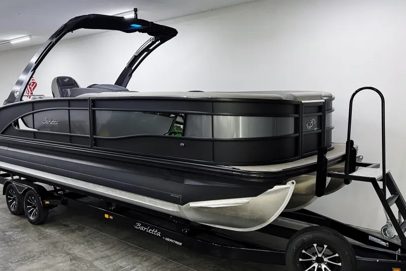 Slide: The Image of 2023 Barletta LUSSO 25U pontoon boat on trailer in showroom. - 2