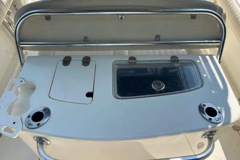 Slide: The Image of 2008 Mako 264 Center Console boat with storage compartments and rod holders. - 10