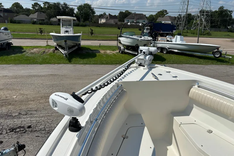 Slide: The Image of 2008 Mako 264 Center Console boat with trolling motor, parked on a lot with other boats. - 5