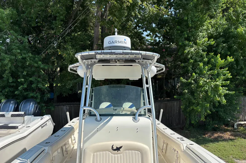 Slide: The Image of 2008 Mako 264 Center Console boat with Garmin equipment, surrounded by lush greenery. - 6