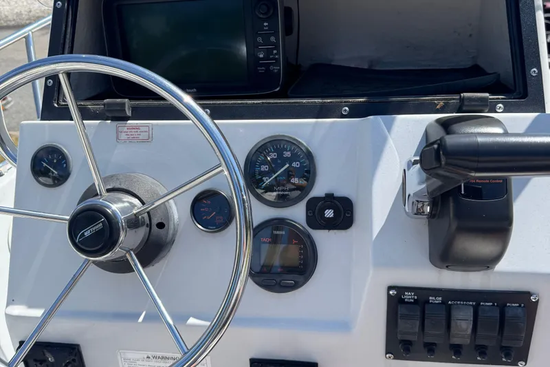 Slide: The Image of Dashboard of a 1997 Boston Whaler Outrage 17 boat with steering wheel and gauges. - 4