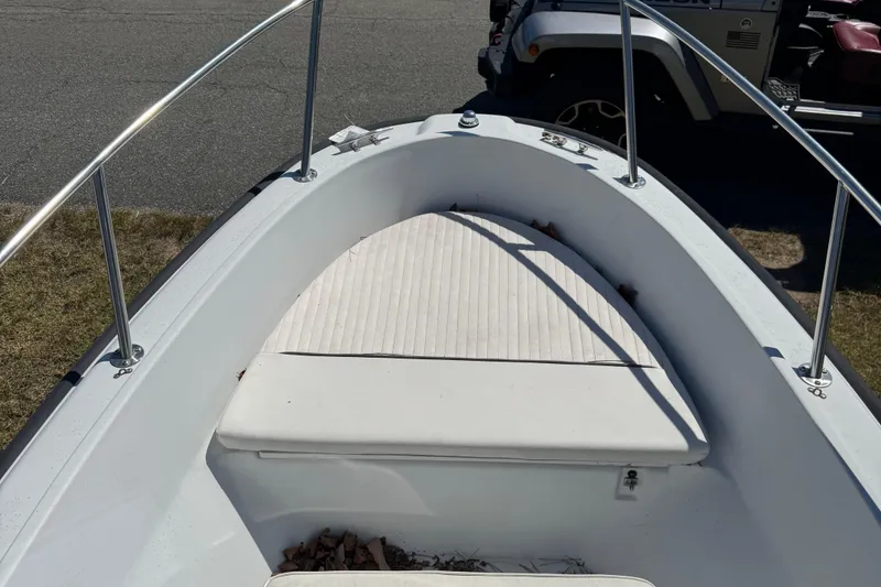 Slide: The Image of 1997 Boston Whaler Outrage 17 boat bow with cushioned seating and stainless steel railings. - 5