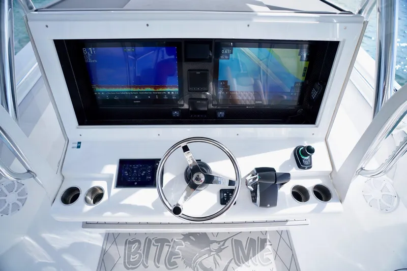Slide: The Image of 2023 SeaHunter 41 CTS helm with dual screens and steering wheel, featuring "Bite Me" logo. - 14
