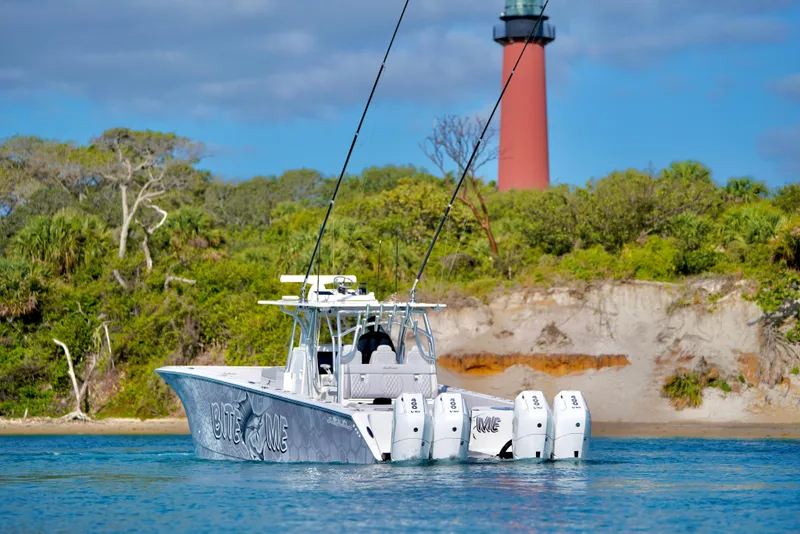 Slide: The Image of 2023 SeaHunter 41 CTS boat near a lighthouse, with lush greenery in the background. - 2