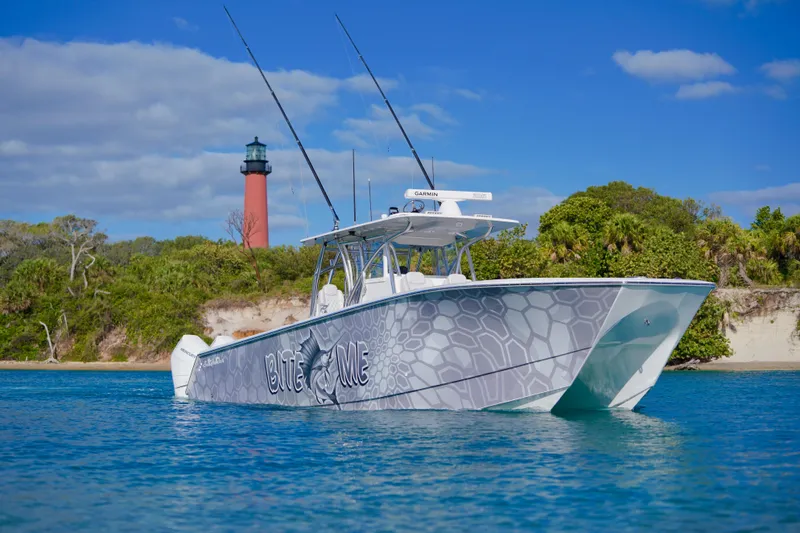 Slide: The Image of 2023 SeaHunter 41 CTS boat on water near a lighthouse and lush greenery. - 21