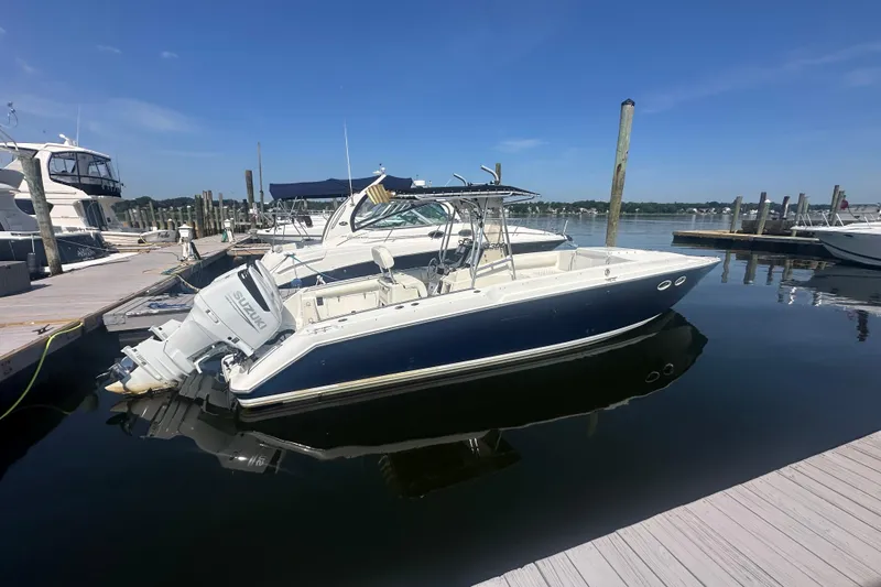 The Image of 1994 Donzi 3300 Center Console boat docked at marina under clear blue sky. - 1