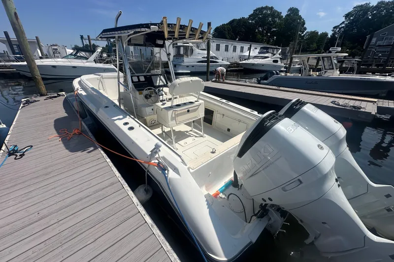 Slide: The Image of 1994 Donzi 3300 Center Console boat docked with dual Suzuki outboard engines. - 3