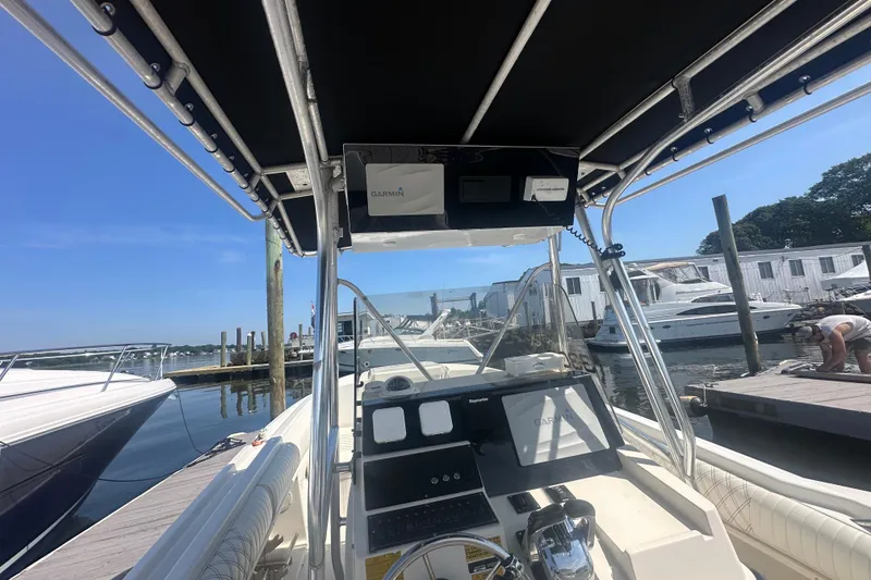 Slide: The Image of 1994 Donzi 3300 Center Console boat docked at marina, featuring Garmin navigation system. - 5