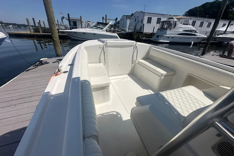 Slide: The Image of 1994 Donzi 3300 Center Console boat docked, featuring spacious seating and sleek design. - 6