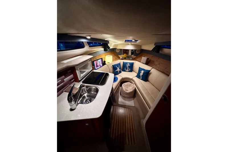 Slide: The Image of Interior of 2007 Bayliner 245 Ciera boat with cozy seating and nautical decor. - 4