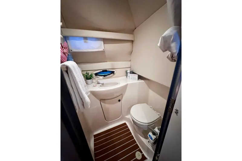 Slide: The Image of Compact bathroom in 2007 Bayliner 245 Ciera boat, featuring toilet, sink, and window. - 6