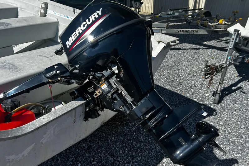 Slide: The Image of Outboard motor on a 1997 Monark SF 14 S boat, parked on gravel. - 7