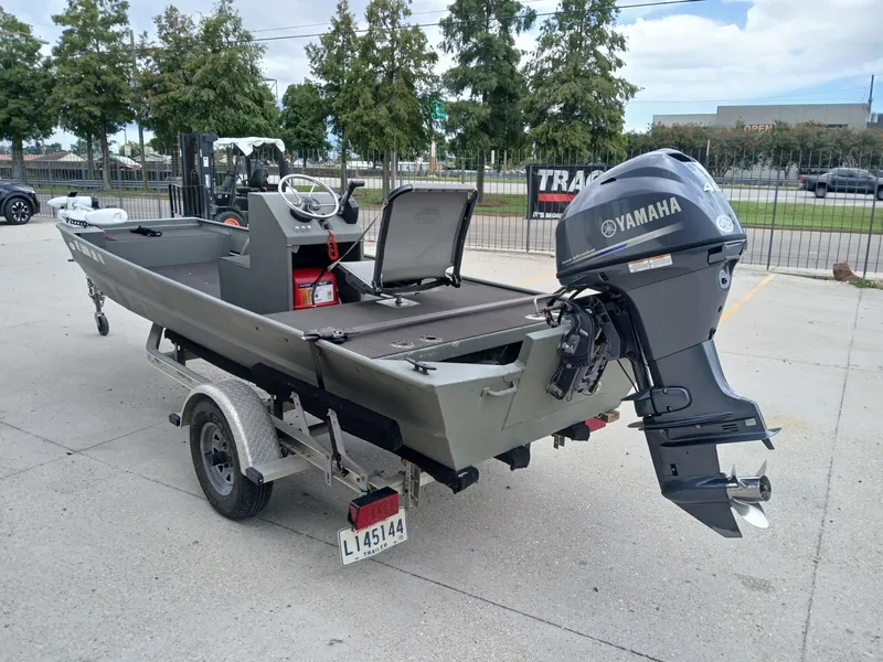 Slide: The Image of 2000 Southfork 16 CC boat with Yamaha outboard motor on a trailer, parked outdoors. - 11