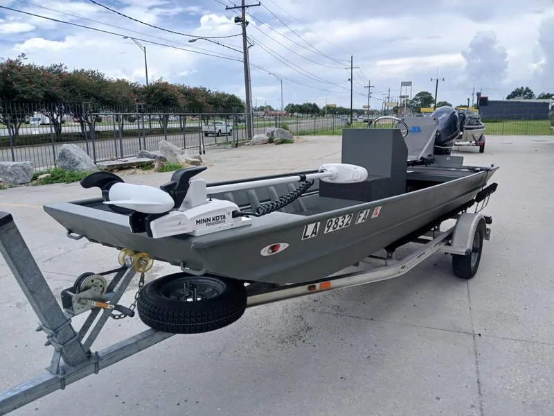 Slide: The Image of 2000 Southfork 16 CC boat on trailer with Minn Kota motor, parked outdoors. - 9