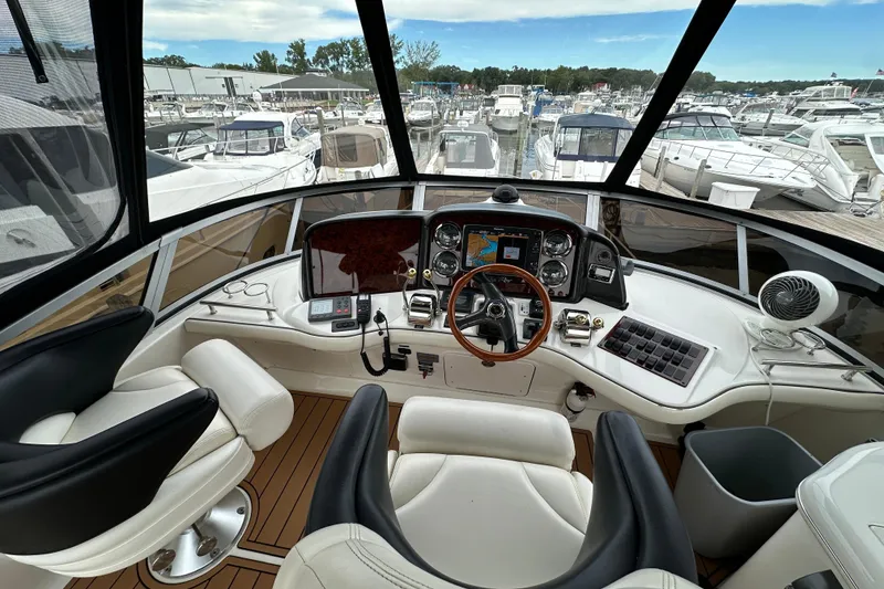 Slide: The Image of 2004 Sea Ray 420 Sedan Bridge helm with modern controls and marina view. - 10