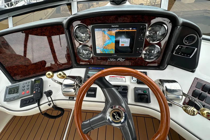 Slide: The Image of 2004 Sea Ray 420 Sedan Bridge helm with navigation system and wooden steering wheel. - 11