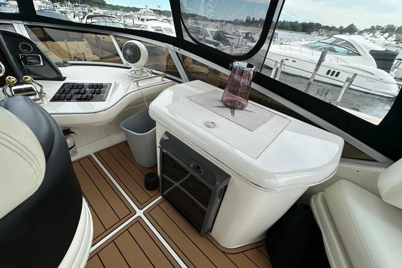 Slide: The Image of 2004 Sea Ray 420 Sedan Bridge interior with helm, seating, and marina view. - 13