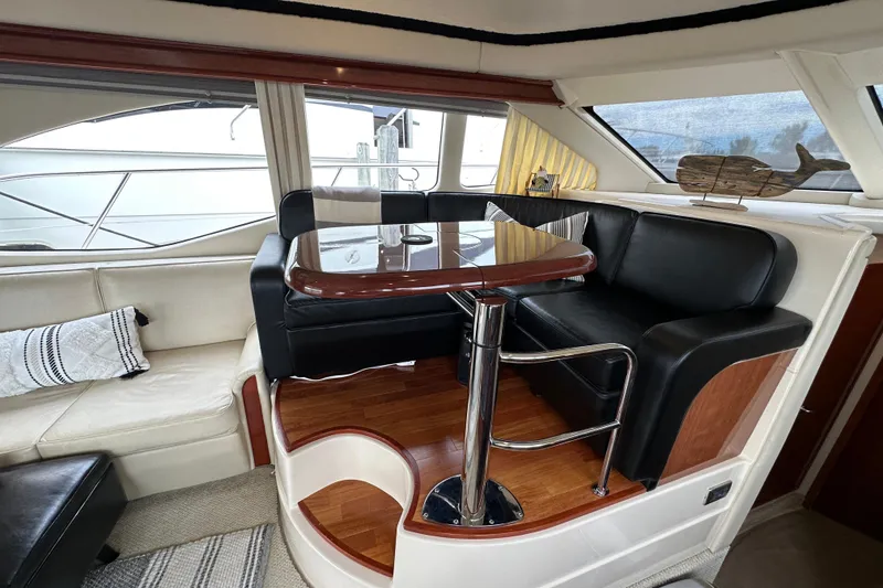 Slide: The Image of Luxurious interior of 2004 Sea Ray 420 Sedan Bridge with elegant seating and table. - 16