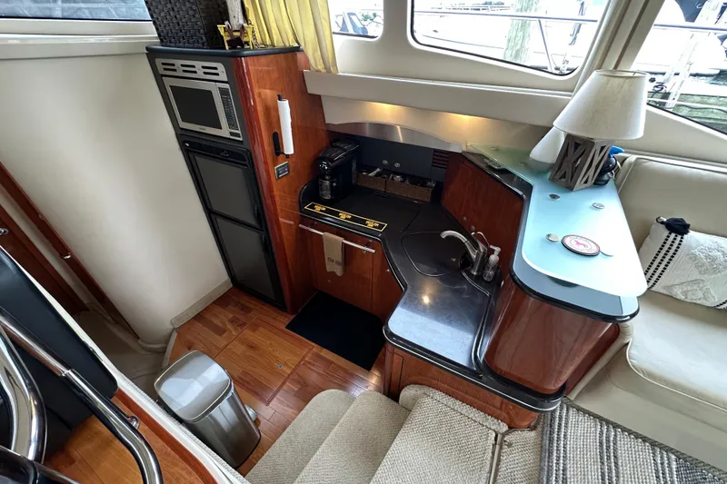 Slide: The Image of 2004 Sea Ray 420 Sedan Bridge yacht interior with modern kitchen and cozy seating area. - 17