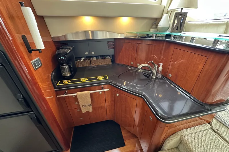 Slide: The Image of Luxurious 2004 Sea Ray 420 Sedan Bridge yacht kitchen with modern amenities and elegant wood finish. - 18