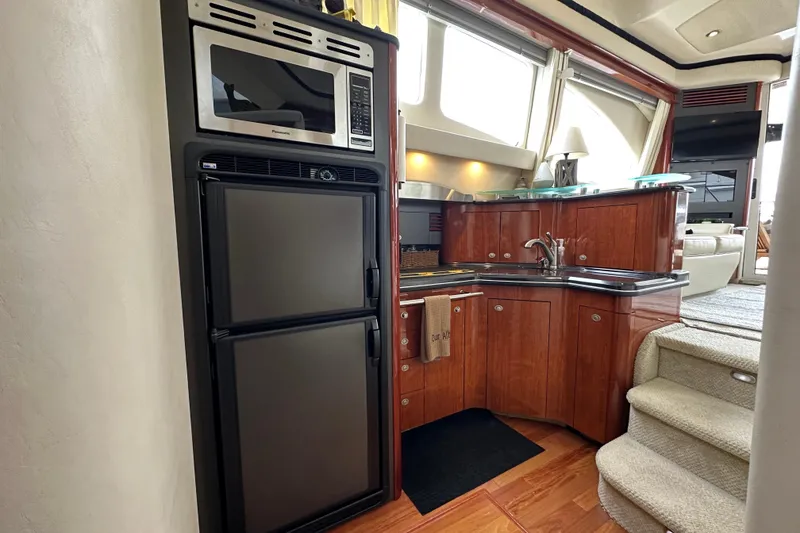 Slide: The Image of Luxurious 2004 Sea Ray 420 Sedan Bridge yacht kitchen with modern appliances and elegant wood cabinetry. - 19