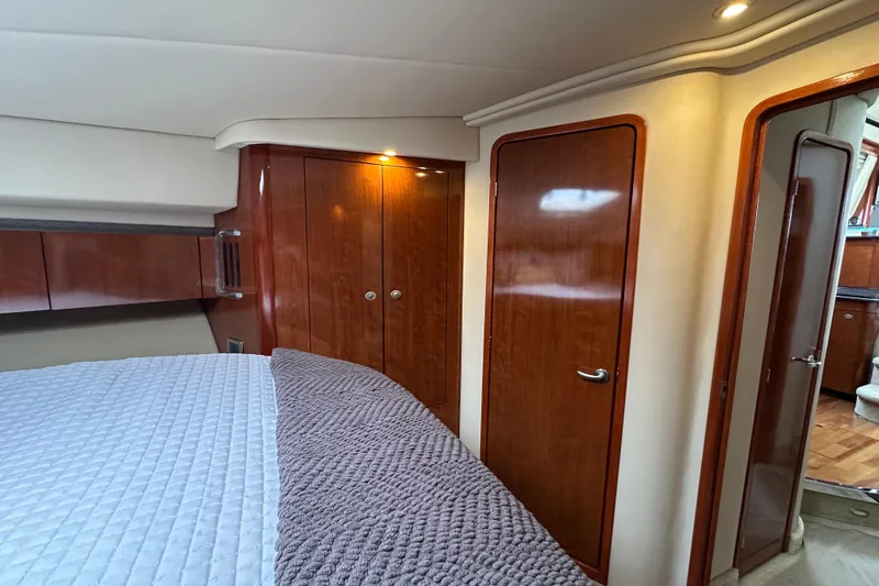 Slide: The Image of Luxurious 2004 Sea Ray 420 Sedan Bridge cabin with wood finishes and cozy bedding. - 22