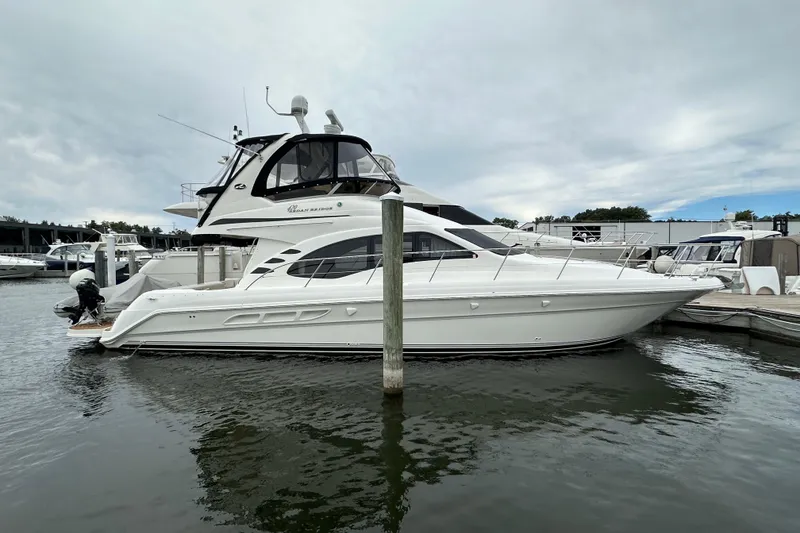 Slide: The Image of 2004 Sea Ray 420 Sedan Bridge yacht docked at marina under cloudy sky. - 35