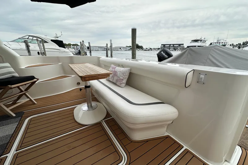 Slide: The Image of Luxurious 2004 Sea Ray 420 Sedan Bridge yacht interior with elegant seating and wooden table. - 6