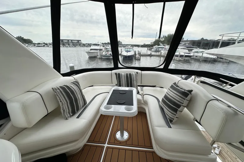 Slide: The Image of Luxurious 2004 Sea Ray 420 Sedan Bridge yacht interior with striped cushions and marina view. - 9