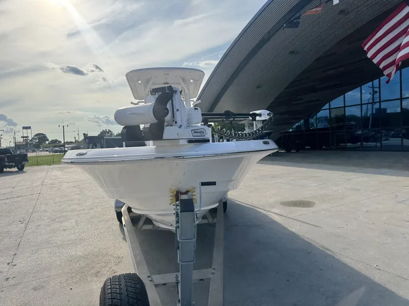 Slide: The Image of 2025 Caymas HB 28 boat on trailer, parked outside a modern building with American flag. - 12