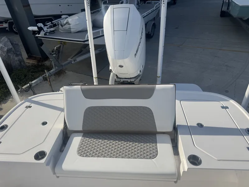 Slide: The Image of 2025 Caymas HB 28 boat with cushioned seating and Mercury outboard motor. - 2