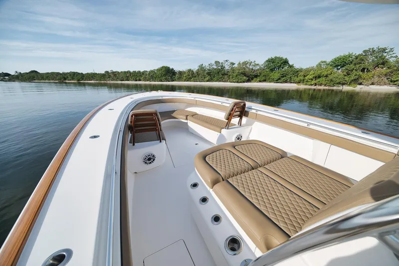Slide: The Image of 2022 Valhalla Boatworks V-41 with luxurious seating, docked near a serene shoreline. - 13