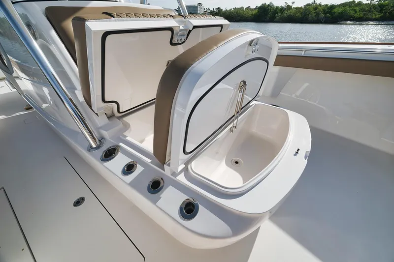 Slide: The Image of 2022 Valhalla Boatworks V-41 with open storage compartment, sleek design, and water backdrop. - 27