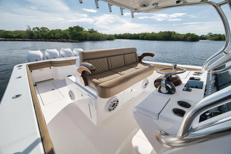 Slide: The Image of 2022 Valhalla Boatworks V-41 interior with luxurious seating and modern controls on a serene waterway. - 43