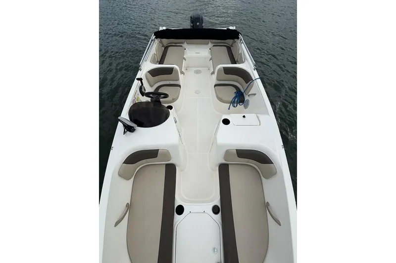 Slide: The Image of 2017 Bayliner Element F21 boat interior with seating and steering wheel on water. - 10