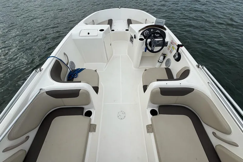 Slide: The Image of 2017 Bayliner Element F21 boat interior with seating and steering wheel on water. - 6